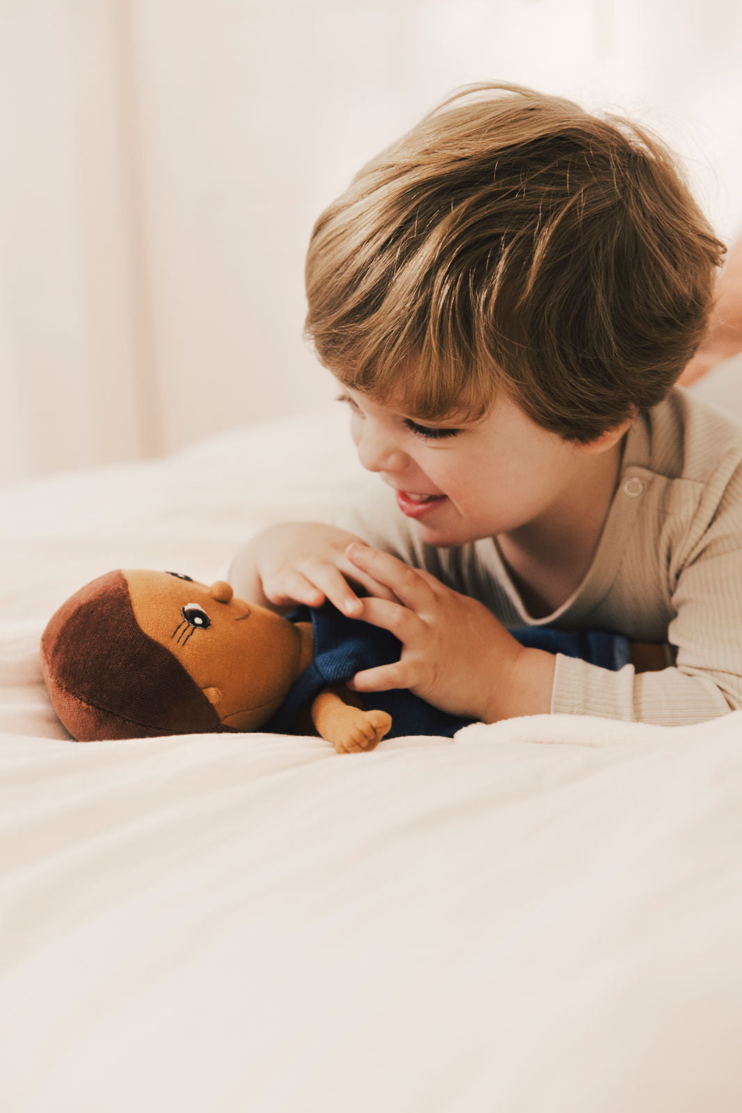 Ein Kleinkind spielt mit einer Bio-Stoffpuppe von LITTLE ASHÉ