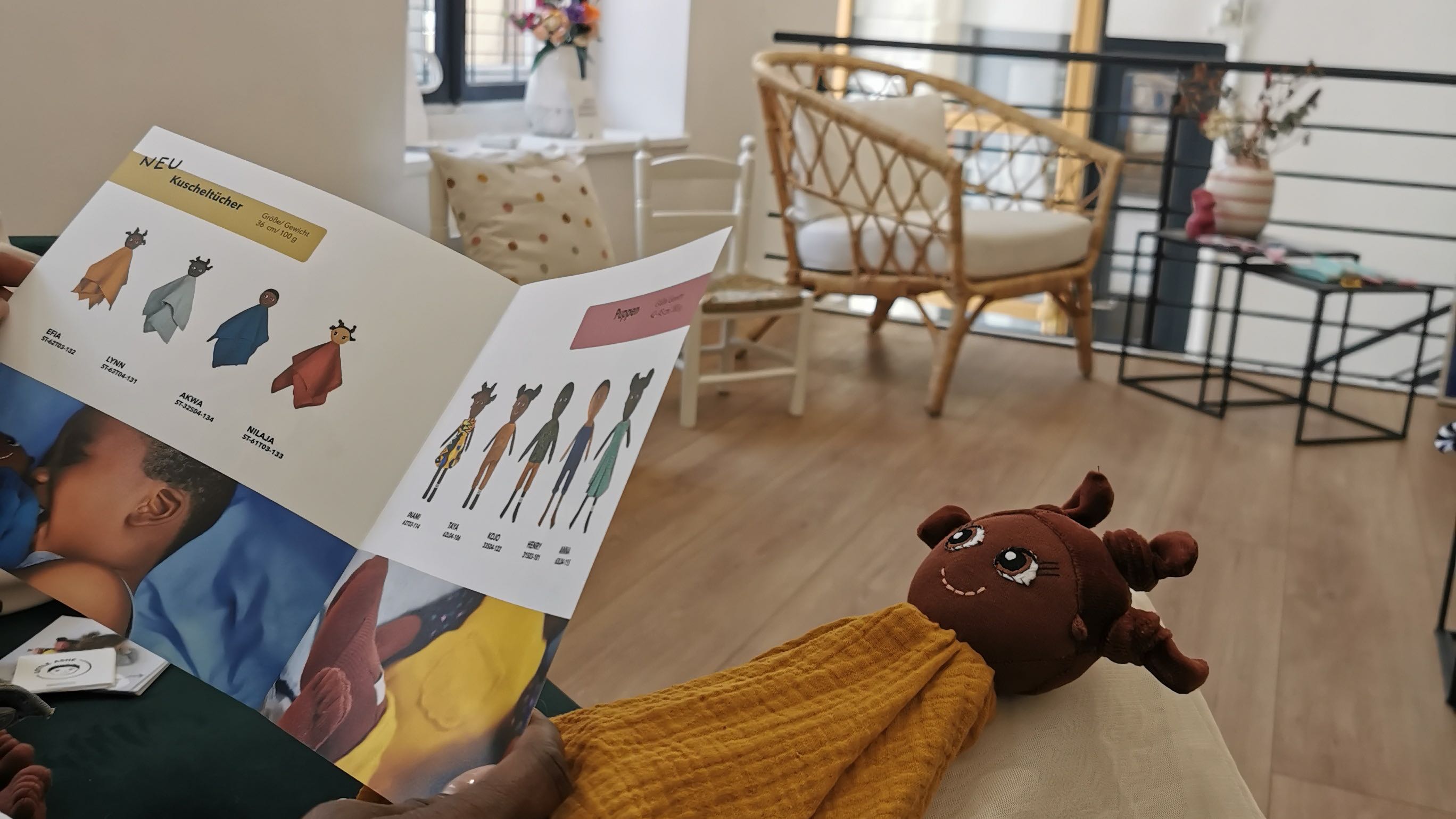 Ein Kuscheltuch und der Katalog von LITTLE ASHÉ in einem Laden